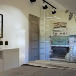 Pokój młodzieżowy na poddaszu z tapetą w stylu podróżniczym, przedstawiającą busa i drogowskazy do miast takich jak Miami, Los Angeles, Warszawa i Nowy Jork. Białe meble, drabinka i lampa podłogowa...