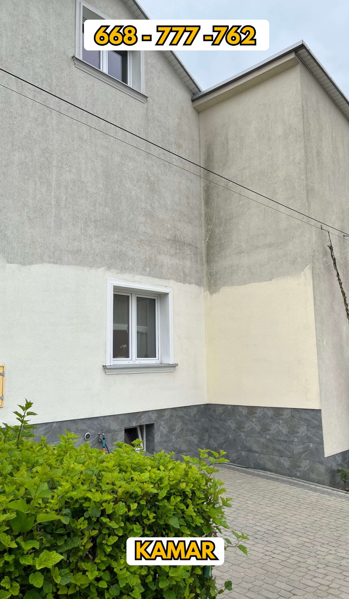 Dwukondygnacyjny budynek z częściowo odnowioną elewacją, widoczne różnice w kolorze i fakturze tynku, zieleń krzewów na pierwszym planie, numer telefonu naniesiony na górze kadru.
