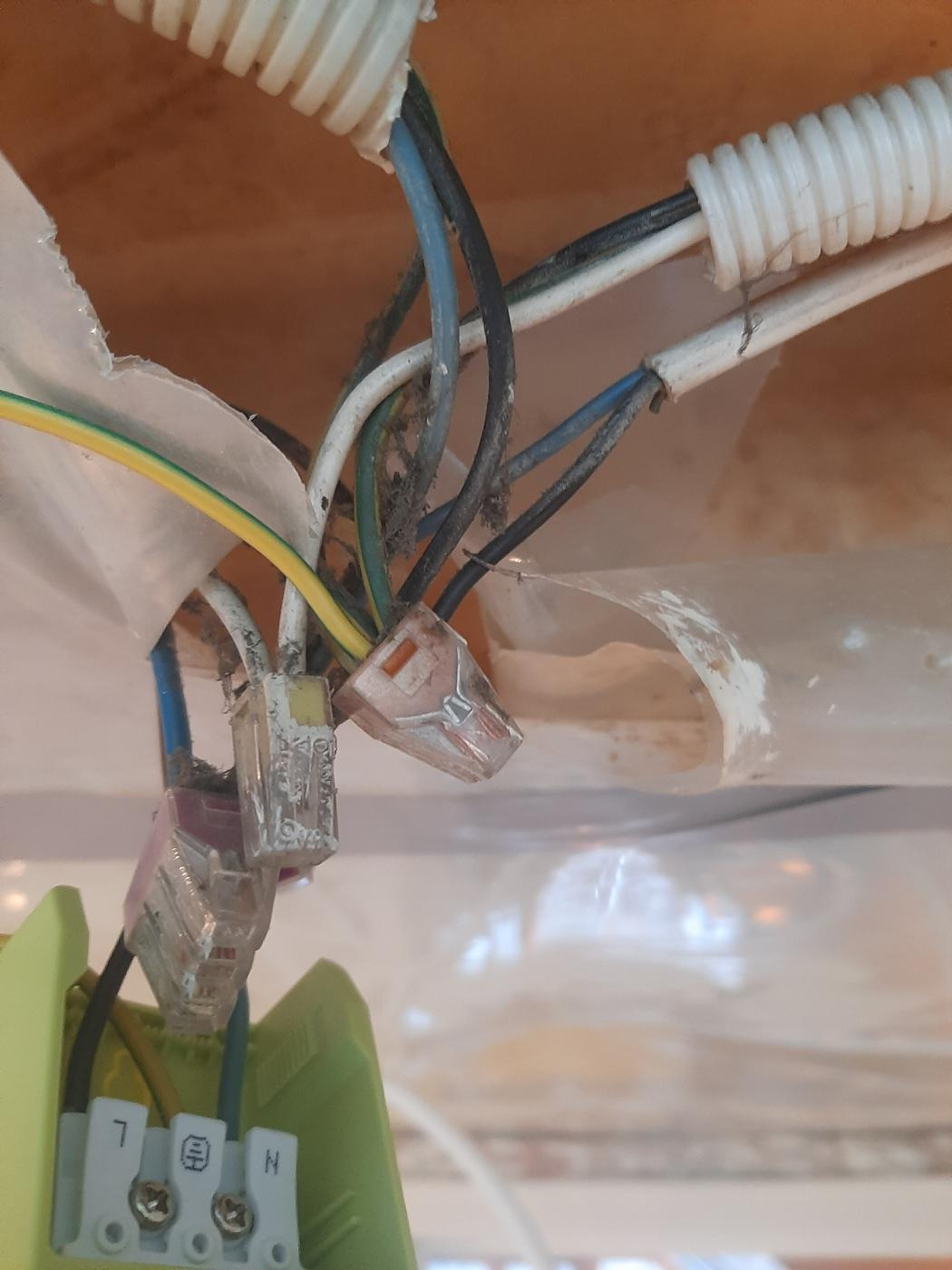 Połączenia elektryczne: przewody w listwie zaciskowej i złączkach WAGO, widoczne przewody w różnych kolorach oraz peszel ochronny.