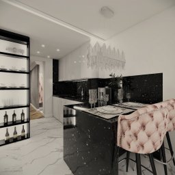 NAJ House Anna Najdek - Wnętrze kuchni z czarnym blatem i marmurową podłogą; widoczne krzesła barowe z pikowanym obiciem, szklana witryna z zastawą i butelkami wina oraz kryształowy żyrandol.