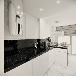 NAJ House Anna Najdek - Nowoczesna kuchnia w bieli i czerni, z błyszczącym czarnym blatem z motywem gwiazd, chromowaną armaturą i minimalistycznym okapem, oświetlona dekoracyjnym żyrandolem. Na blacie ekspres do kawy...