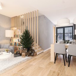 NAJ House Anna Najdek - Jasne, przestronne wnętrze domu z drewnianą podłogą, schodami z ażurową balustradą, biblioteczką i choinką w salonie, oraz jadalnią z widokiem na zimowy krajobraz za oknem.