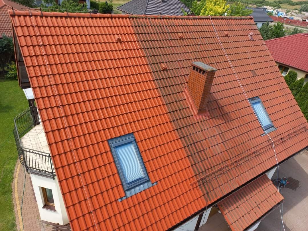 Częściowo wyczyszczony dach z czerwonej dachówki, widoczna różnica między umytą a brudną powierzchnią, komin z cegły, okno dachowe.