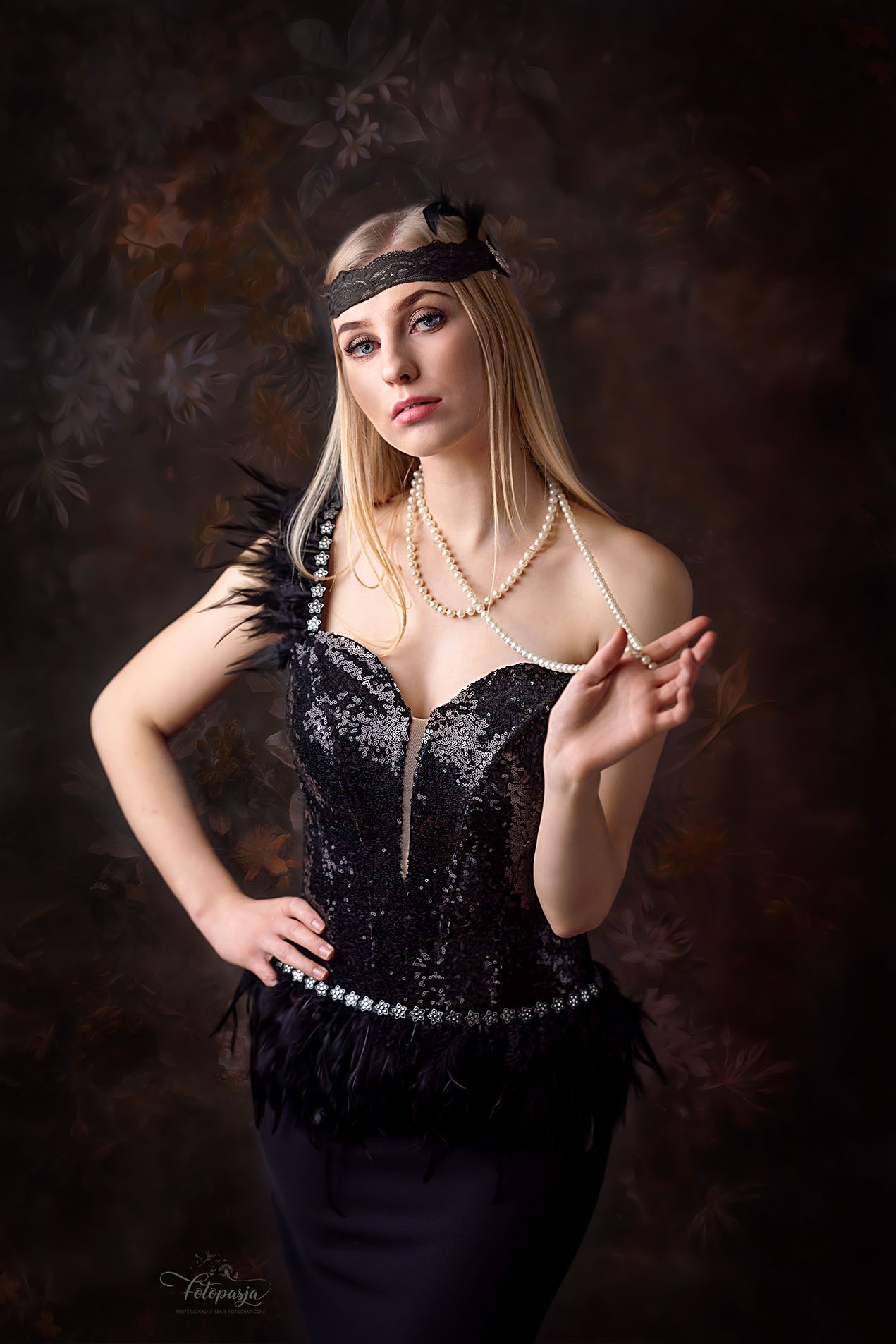 Portret kobiety w czarnej, cekinowej sukni z piórami i opasce na głowie w stylu lat 20., pozującej na tle abstrakcyjnego, ciemnego tła.