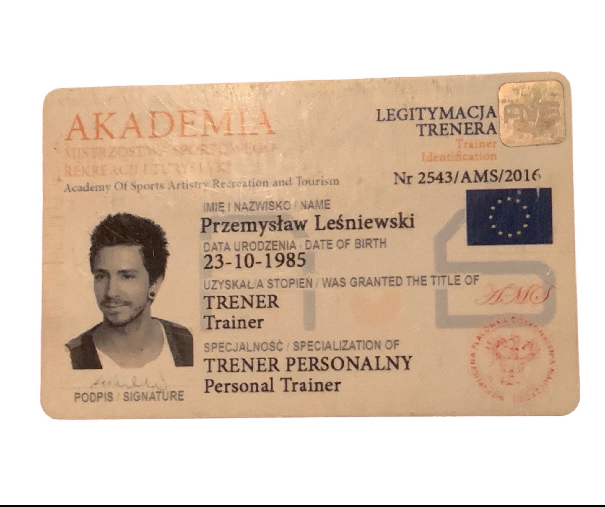 Legitymacja trenera personalnego Przemysława Leśniewskiego z datą urodzenia 23-10-1985, numer 2543/AMS/2016, z fotografią i podpisem.