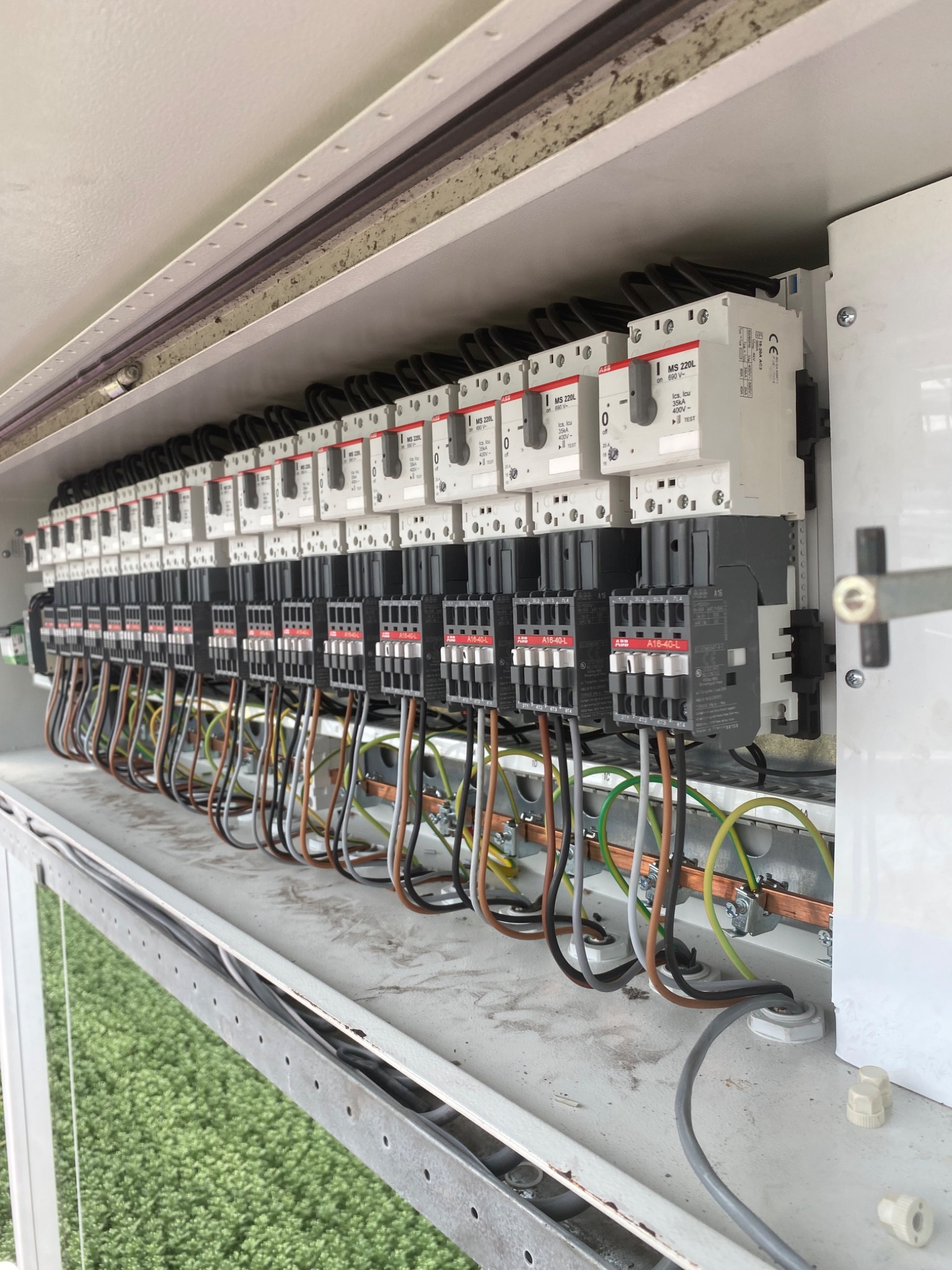 Tablica rozdzielcza z licznymi bezpiecznikami i okablowaniem, widok z góry ukazujący szczegóły połączeń i oznaczenia na urządzeniach.