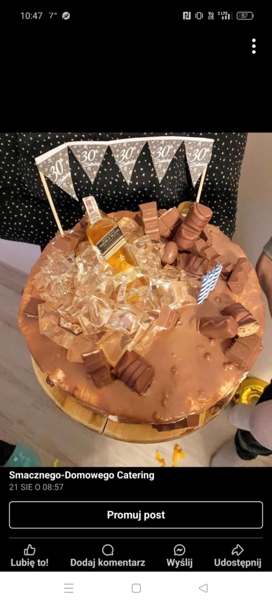 Tort urodzinowy z polewą czekoladową, dekorowany kostkami lodu, batonikami Kinder Bueno i miniaturową butelką whisky. Flagi z napisem '30 Birthday'.