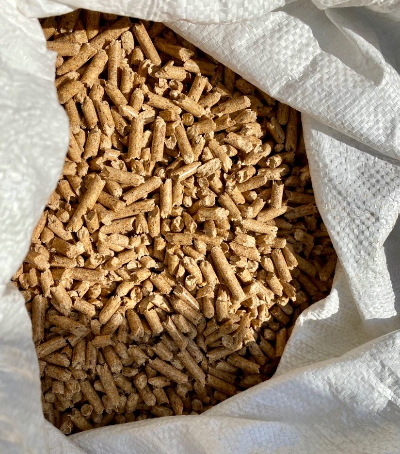 Wnętrze worka wypełnionego jasnymi, drewnianymi granulkami w Masłowie, prawdopodobnie paliwo ekologiczne.