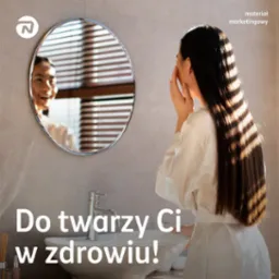 Kobieta w szlafroku dotyka twarzy, patrząc w okrągłe lustro w łazience z żaluzjami, odbijające jej uśmiechniętą twarz; na dole widoczny fragment umywalki i kranu.