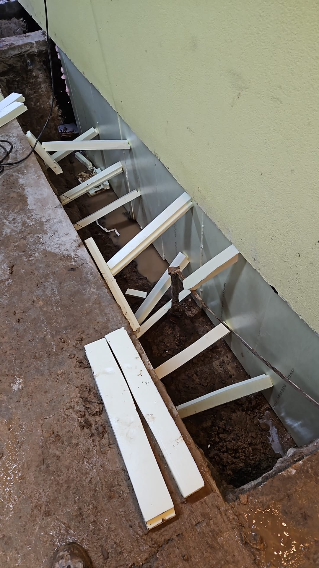 Wykop pod przyszły budynek w Dębicy z widocznymi deskami szalunkowymi i izolacją termiczną ścian.