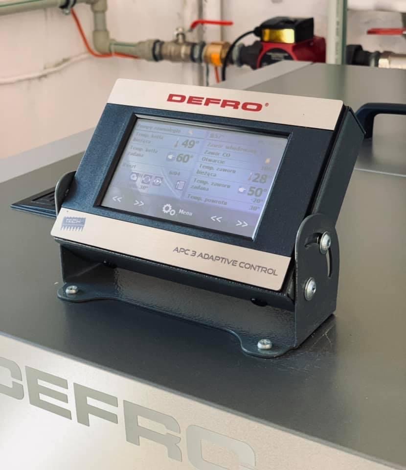 Sterownik APC 3 Adaptive Control firmy Defro, zamontowany na kotle grzewczym, widoczny na tle instalacji hydraulicznej w Kazimierzy Wielkiej.