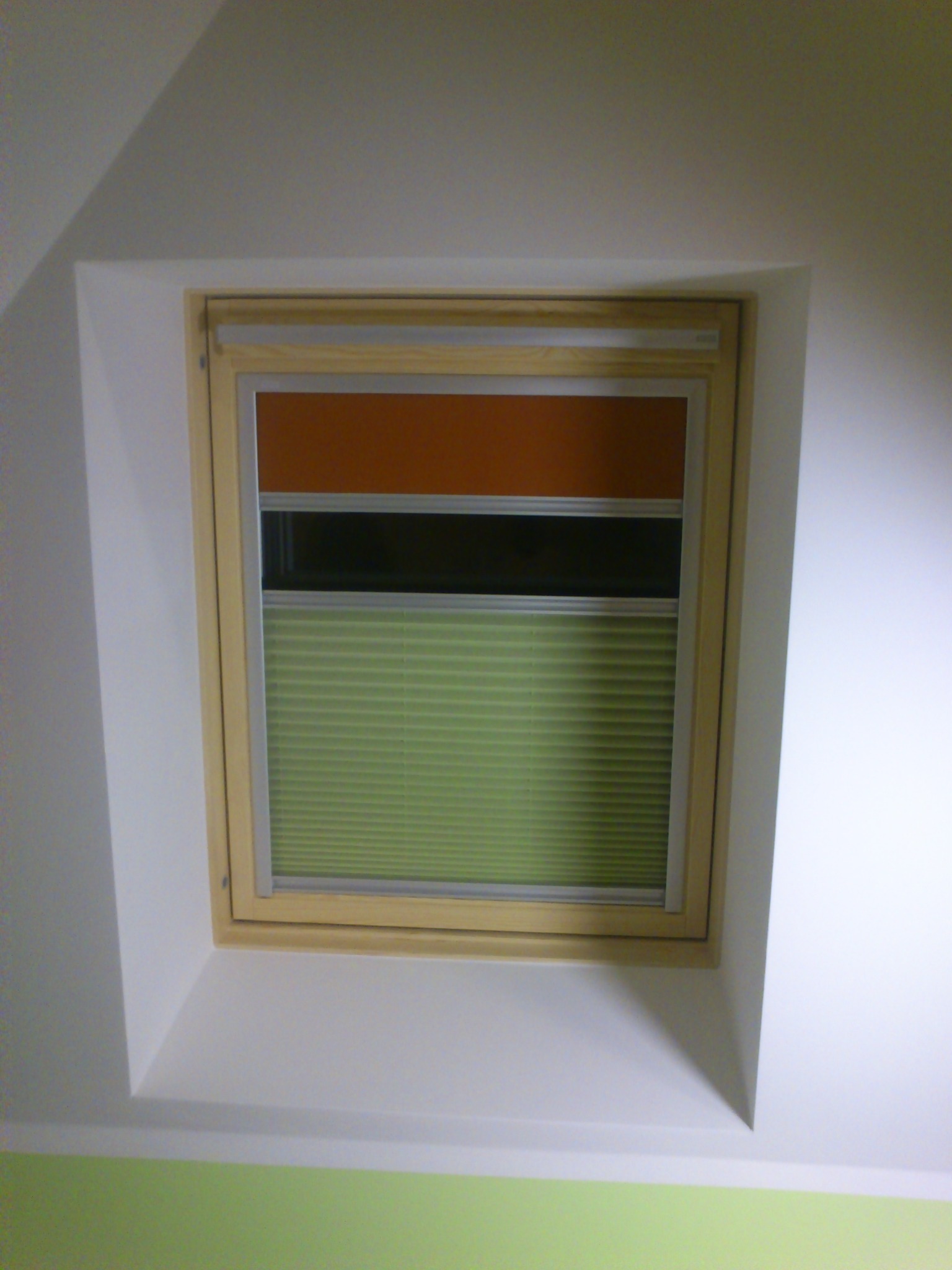 Plisa z roletą na oknie dachowym.