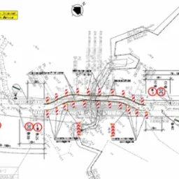 Plan sytuacyjny przebudowy drogi z oznaczeniami geodezyjnymi, znakami drogowymi i barierami ochronnymi.