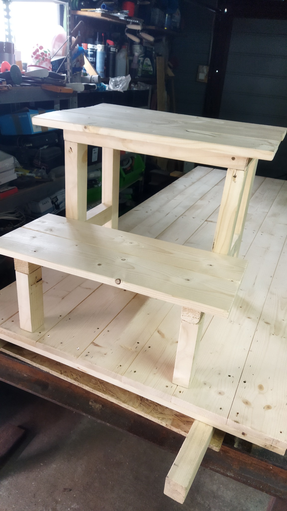 Surowe, drewniane schodki/podesty wykonane z jasnego drewna, z widocznymi śladami montażu i niedoskonałościami, ustawione w warsztacie.