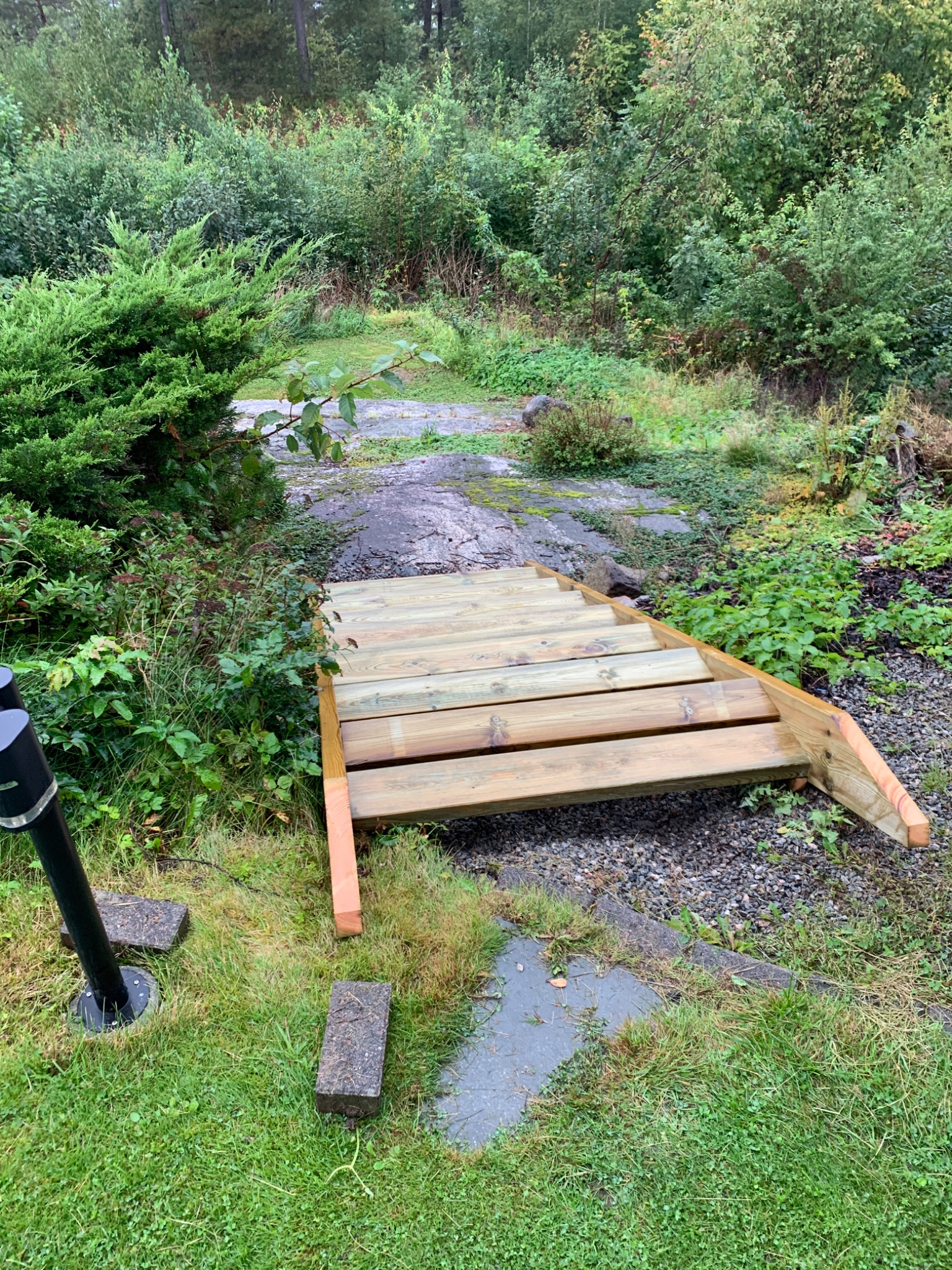 Nowe drewniane schody ogrodowe prowadzące w górę, otoczone bujną zielenią w Złocieńcu.