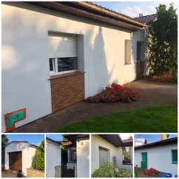 Biała elewacja domu jednorodzinnego z oknem z roletą, ceglanym podmurowaniem i zabezpieczonym elementem. Widoczne rośliny i fragment chodnika.