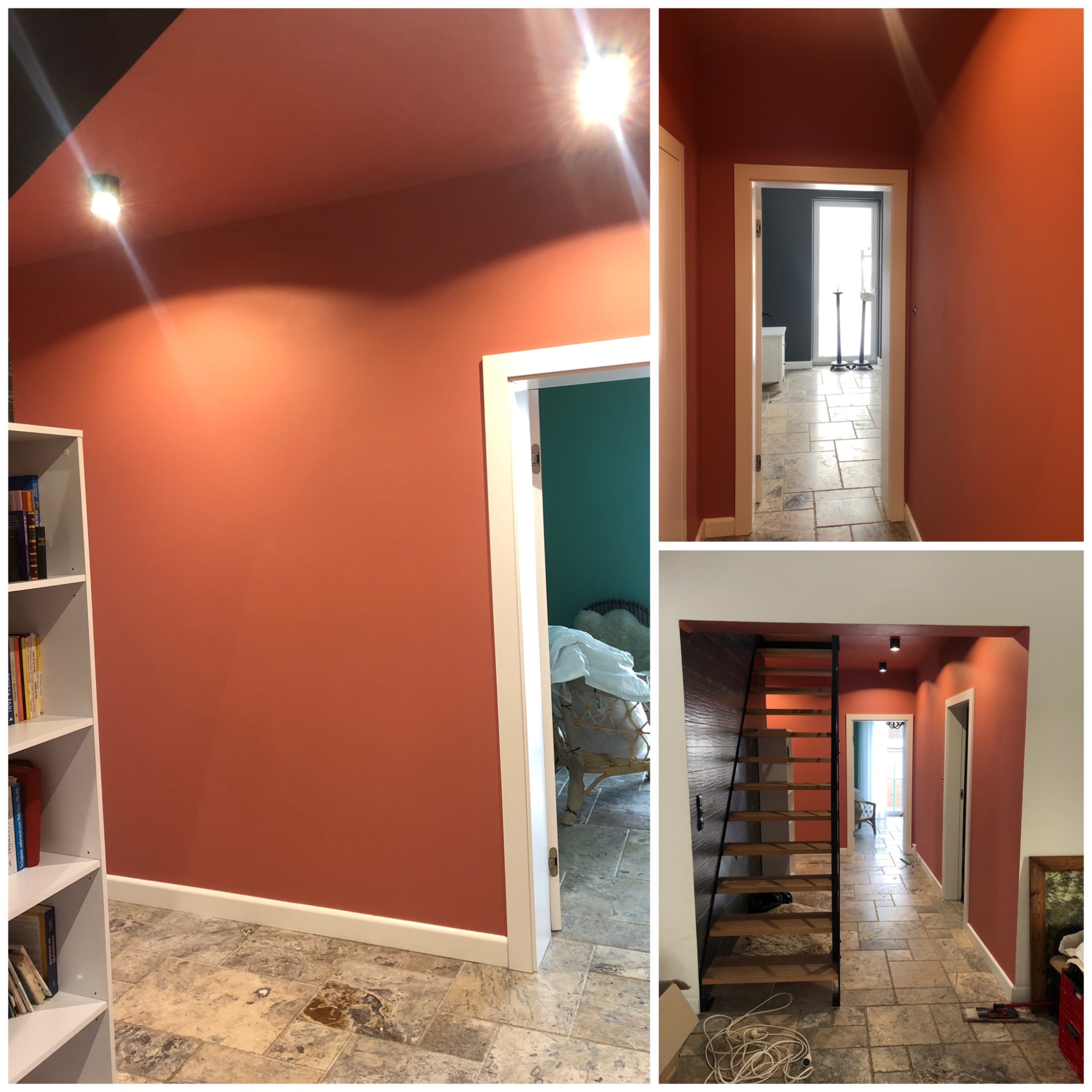 Pomarańczowe ściany korytarza po malowaniu, widoczne płytki podłogowe imitujące kamień, białe listwy przypodłogowe i ościeżnice, oświetlenie sufitowe punktowe, regał z książkami oraz schody drewniane.