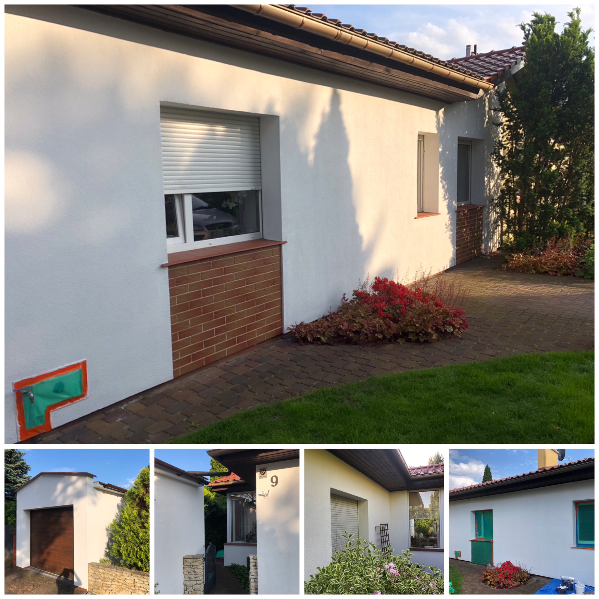 Biała elewacja domu jednorodzinnego z oknem z roletą, ceglanym podmurowaniem i zabezpieczonym elementem. Widoczne rośliny i fragment chodnika.