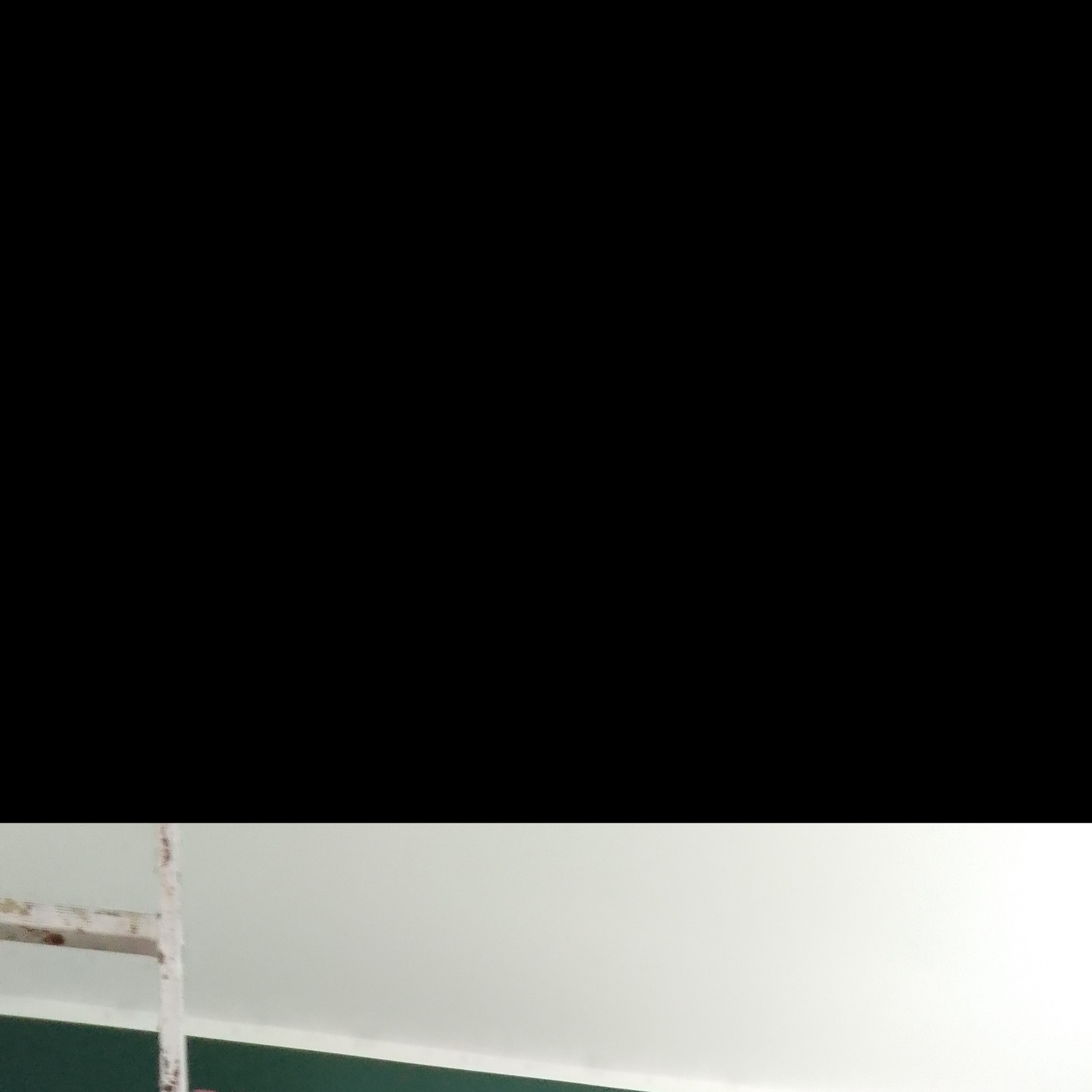 Fragment pomalowanej ściany w Pabianicach z widoczną starą, drewnianą drabiną malarską.