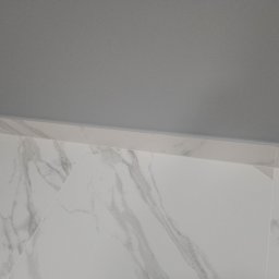 Happy Home - Białe płytki imitujące marmur na podłodze, szara gładź na suficie, widok z dołu, minimalistyczne wykończenie wnętrza.