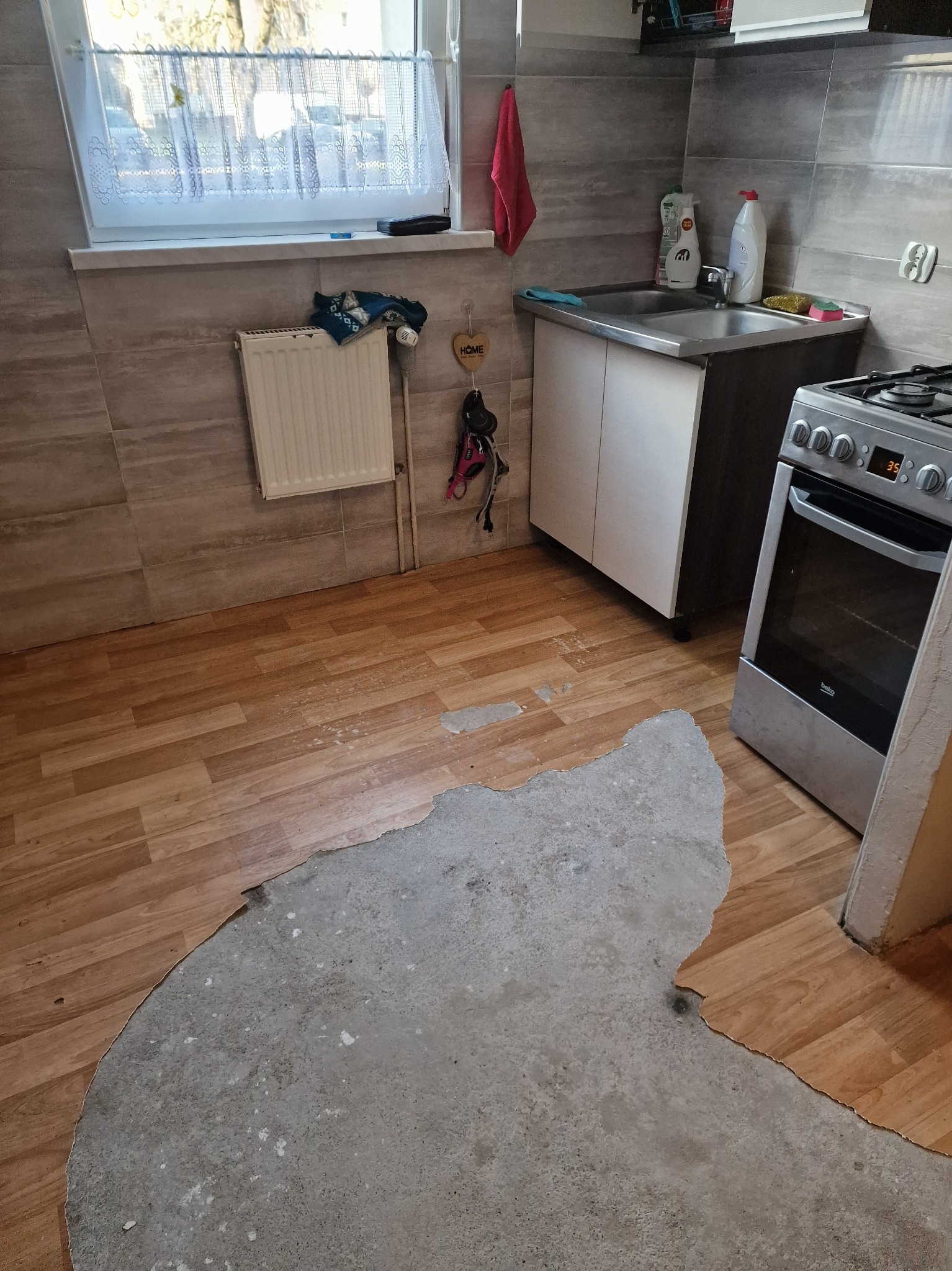 Zerwanie starej okładziny podłogowej, wyrównanie posadzki betonowej oraz ułożenie płytek ceramicznych.