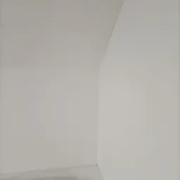 Wnętrze pokoju po szpachlowaniu ścian i sufitu, gotowe do malowania, widoczny surowy beton na podłodze, narożnik ściany i sufitu z delikatnym cieniem.