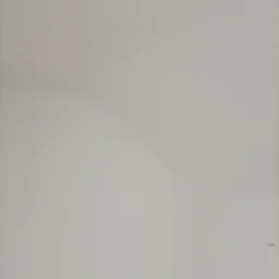 Wnętrze pokoju po malowaniu na biało, widoczne gładkie ściany i sufit pod skosem, z widocznymi puszkami elektrycznymi.