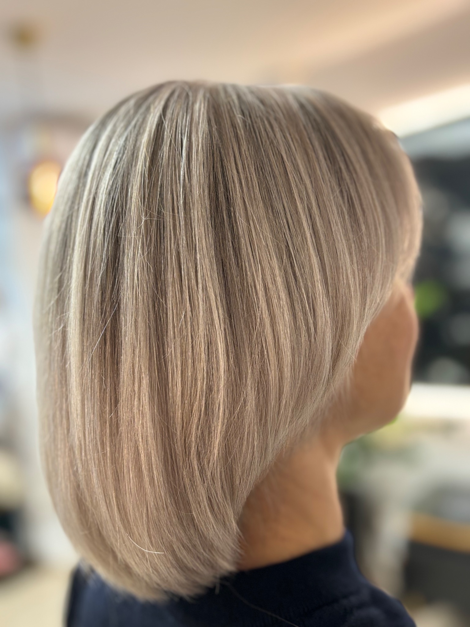 Krótkie, proste, blond włosy z delikatnym cieniowaniem na karku, widok z tyłu, wykonane we Wrocławiu.