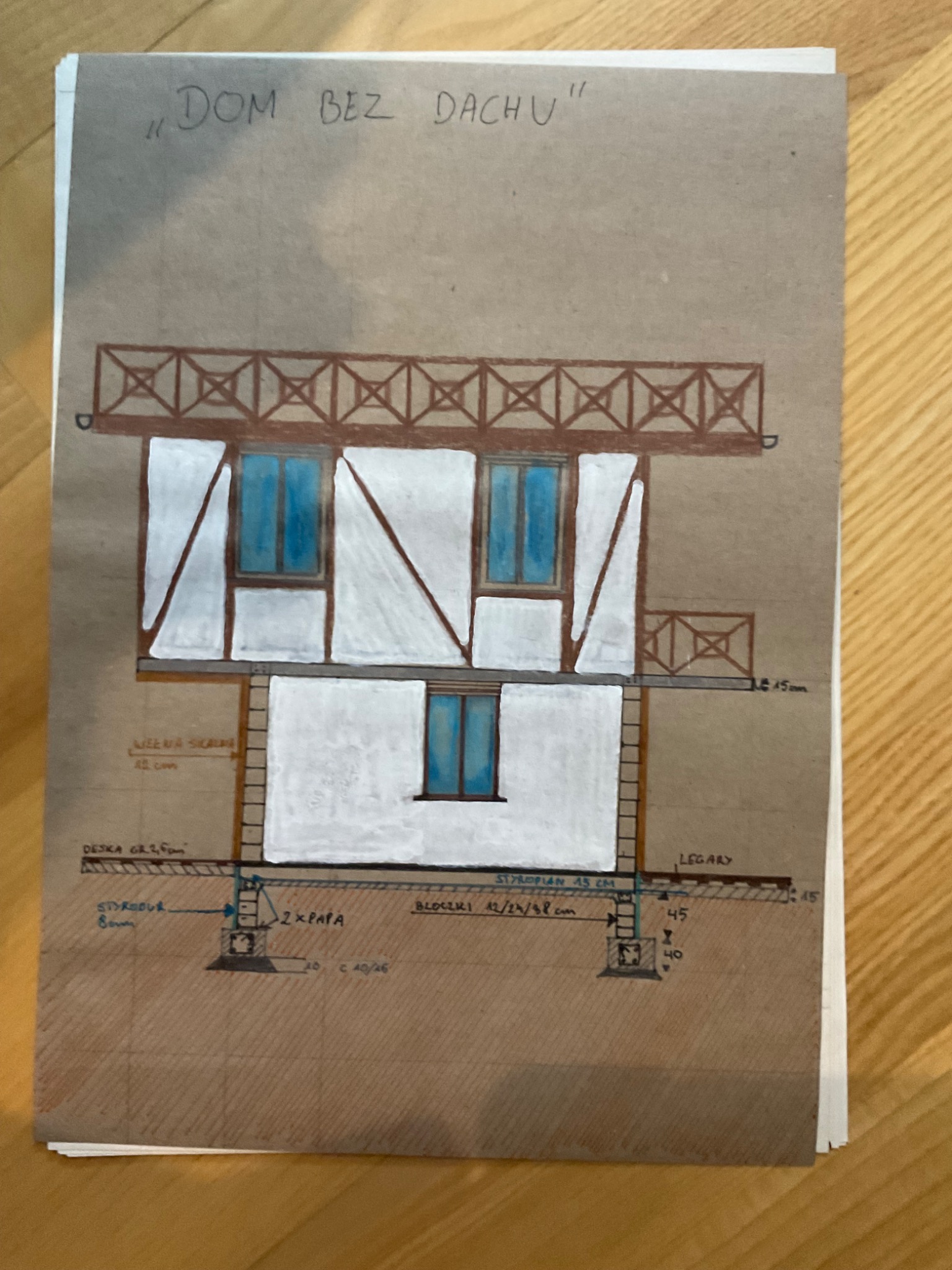 Ręcznie rysowany schemat przekroju budynku dwukondygnacyjnego, z zaznaczonymi warstwami izolacji, wymiarami i napisem 'Dom bez dachu'.