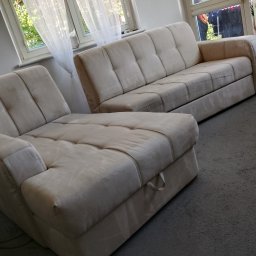 Kacper Bakuła Diamond Professional Cleaning - Jasna, tapicerowana sofa i narożnik z widocznymi przeszyciami i guzikami na siedziskach, ustawione w salonie z oknami zasłoniętymi białymi firankami.