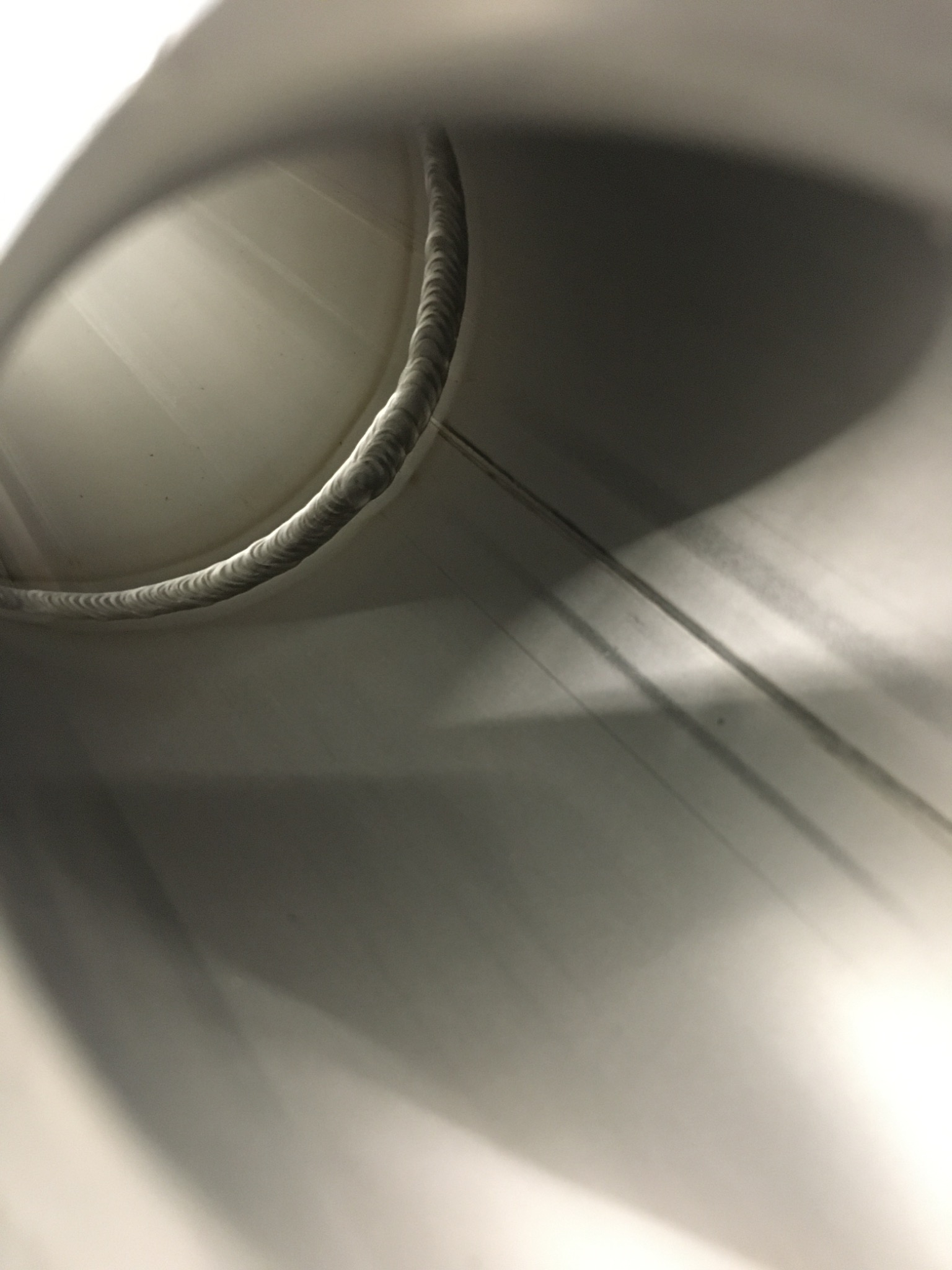 Wnętrze metalowej rury z widocznym spoiną, wykonaną metodą TIG, widoczne ślady obróbki.