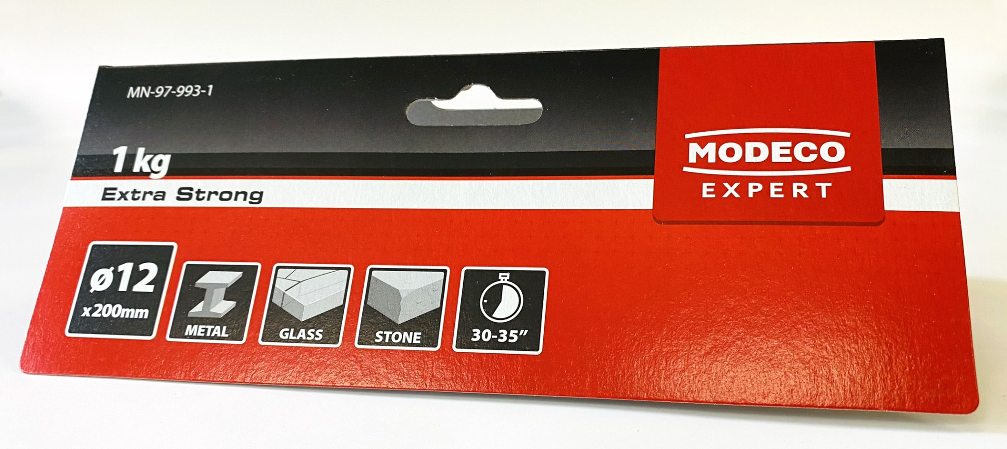 Opakowanie kleju montażowego Modeco Expert, przeznaczonego do łączenia metalu, szkła i kamienia, o wadze 1 kg.