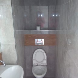 R-F Remonty - Nowoczesna toaleta podwieszana z szarą glazurą, drewnianym akcentem i umywalką nablatową.