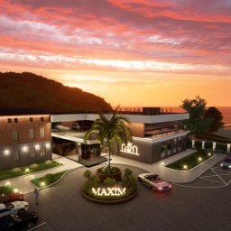 Witwicki Architekt - projekty elewacji - Wizualizacja budynku Maxim z ceglaną fasadą i nowoczesnym skrzydłem, otoczonego zielenią i samochodami. Zachód słońca tworzy dramatyczne tło.