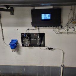 M.R.Service Michał Rowicki - Panel sterujący z wyświetlaczem i podłączonymi czujnikami do monitoringu parametrów wody, zamontowany na ścianie wyłożonej płytkami.