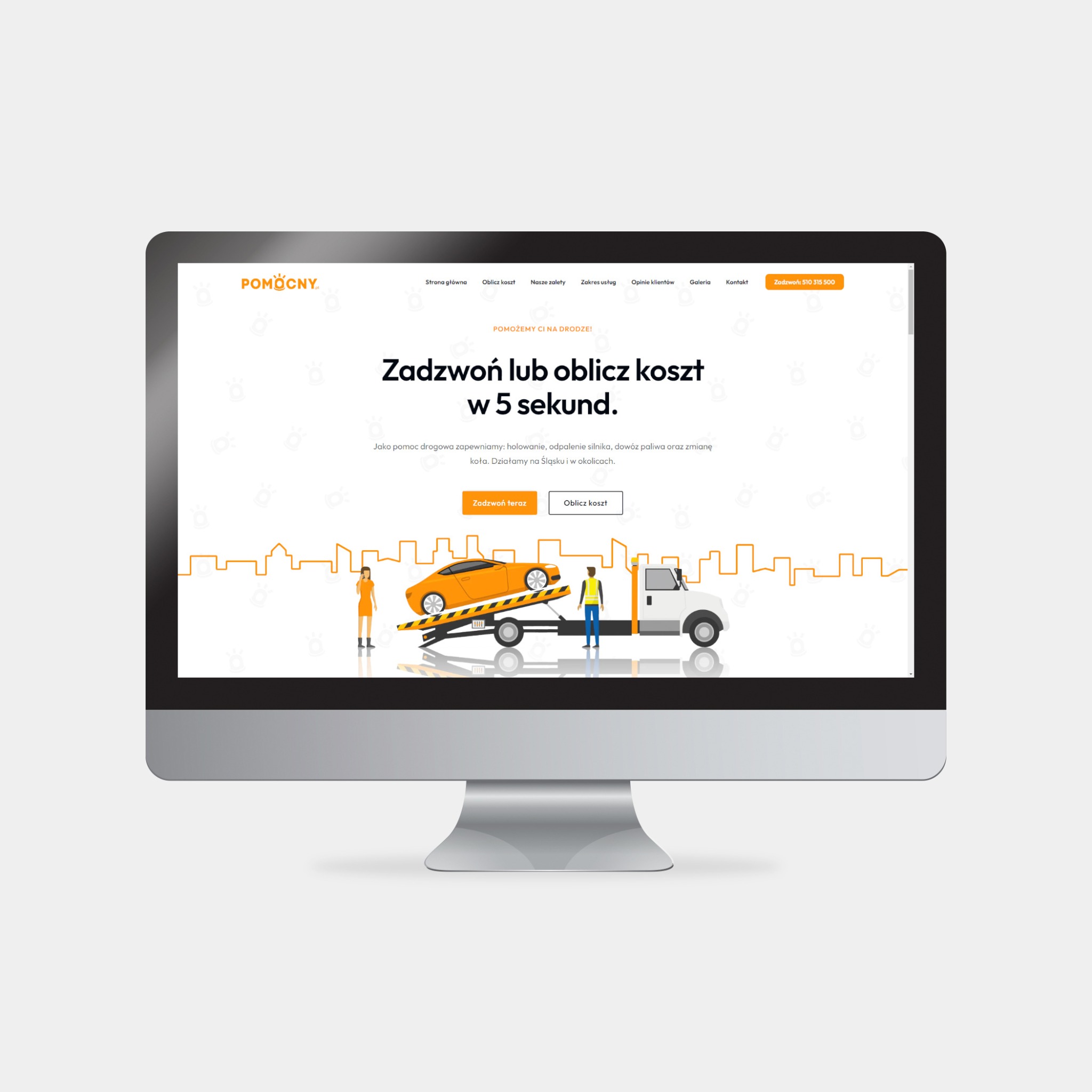 Monitor wyświetla stronę internetową firmy pomocy drogowej z ilustracją lawety z pomarańczowym samochodem, sylwetką miasta w tle i przyciskami 'Zadzwoń teraz' i 'Oblicz koszt'.
