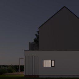 LONKA architektura Kamila Lonka - Dwukondygnacyjny dom z płaskim dachem i balkonem, oświetlony z zewnątrz w nocy. Widoczne drzewa i trawnik. Minimalistyczna architektura.