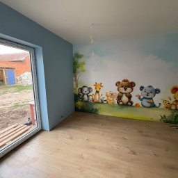 EMa - Miłosz Zadka - Pokój dziecięcy po remoncie: jasne panele, błękitne ściany i mural ze zwierzętami. Widok na zewnątrz przez otwarte okno.