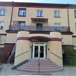 Weldcut spawanie i cięcie s.c. - Wejście do budynku z balustradą i poręczami, widoczne schody i pracownik na drabinie. Balustrada z numerem 10. Elementy metalowe.