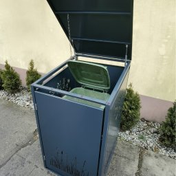 Weldcut spawanie i cięcie s.c. - Nowoczesna, grafitowa obudowa na pojemniki na śmieci z motywem roślinnym, z otwartą klapą i widocznym wkładem, ustawiona na zewnątrz budynku.