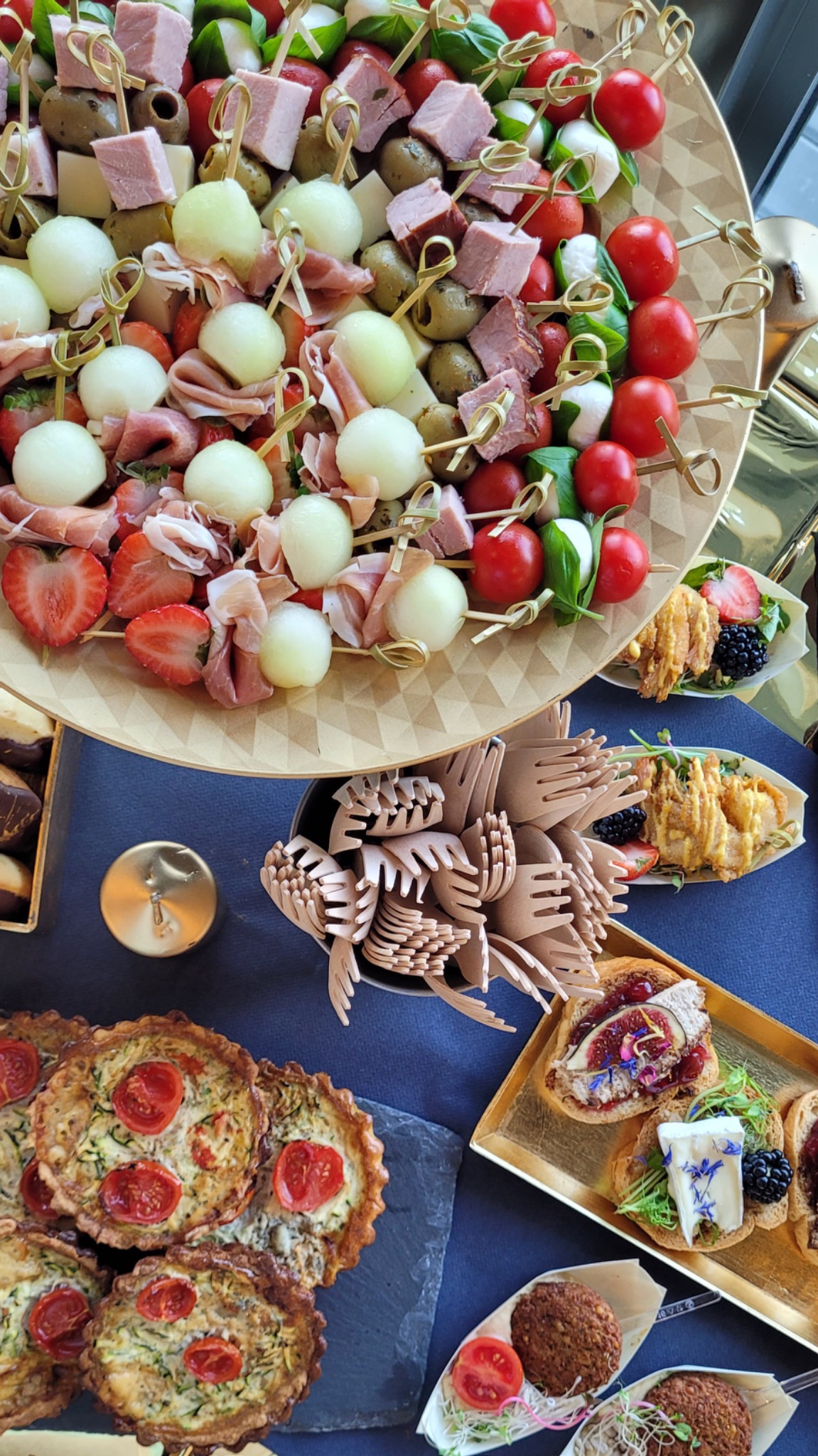 Bogaty wybór przekąsek na przyjęcie: szaszłyki z melonem, szynką parmeńską, pomidorkami cherry i mozzarellą, mini tarty z cukinią i pomidorami, kanapki z figami i serem, oraz kotleciki warzywne...