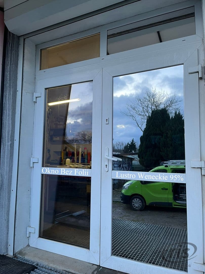 Porównanie okna bez folii i okna z folią lustro weneckie 95% na dwuskrzydłowych, białych drzwiach wejściowych; w odbiciu zielony samochód.