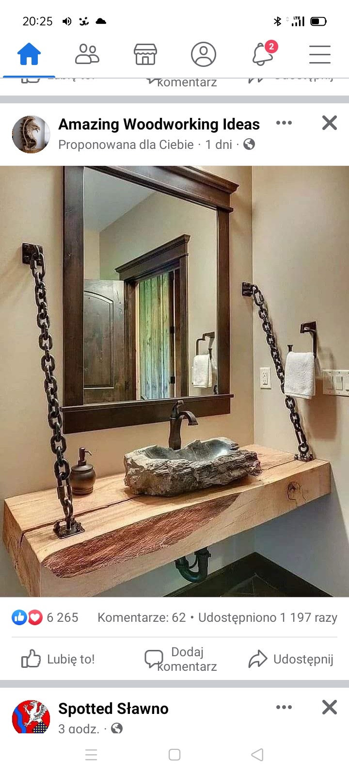 Unikalna łazienka z blatem z litego drewna podtrzymywanym przez łańcuchy, kamienna umywalka i lustro w ciemnej ramie.