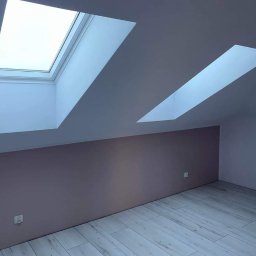 Complex-Wnętrz - Poddasze po remoncie z dwoma oknami dachowymi, ściana pomalowana na dwa kolory: beżowy i biały, podłoga wyłożona panelami imitującymi drewno.