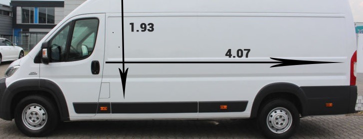 Biały samochód dostawczy z naniesionymi wymiarami: wysokość 1.93m i długość 4.07m, zaparkowany na zewnątrz budynku.