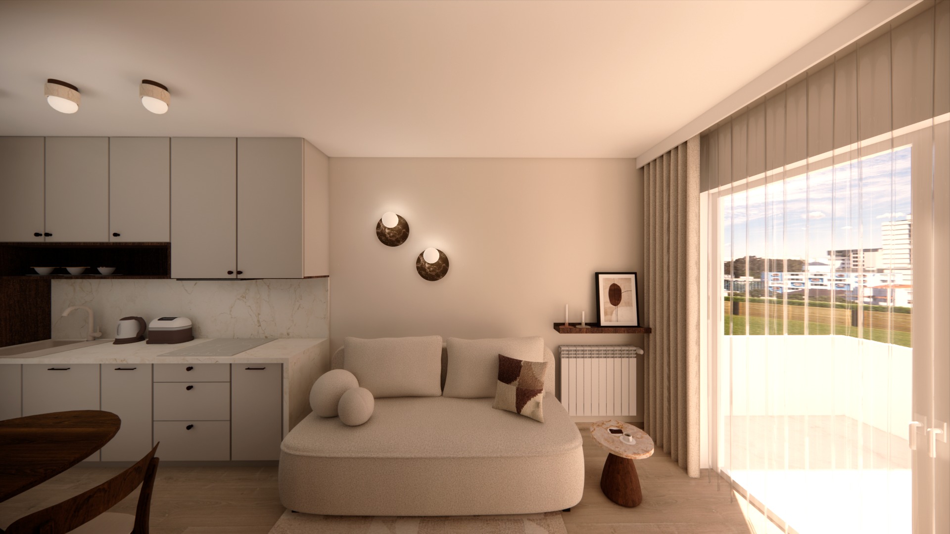 Jasne wnętrze: aneks kuchenny z beżową zabudową, sofa z poduszkami, okno z widokiem na miasto. Dwa okrągłe kinkiety na ścianie. Minimalistyczny design.