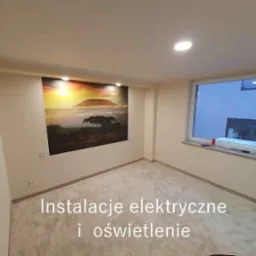 Wnętrze pokoju z nowym oświetleniem sufitowym typu downlight, widoczne puszki elektryczne na ścianie oraz fototapeta z motywem afrykańskiego krajobrazu z górą Kilimandżaro.