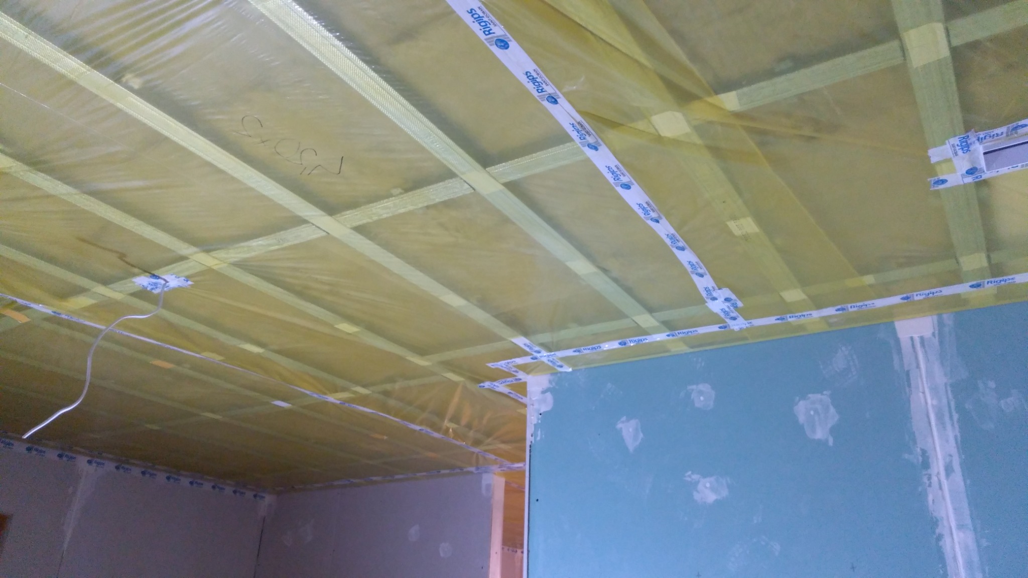 Szkielet sufitu podwieszanego z folią paroizolacyjną i profilami metalowymi, przygotowany pod montaż płyt kartonowo-gipsowych, widoczny w trakcie prac w Warszawie.