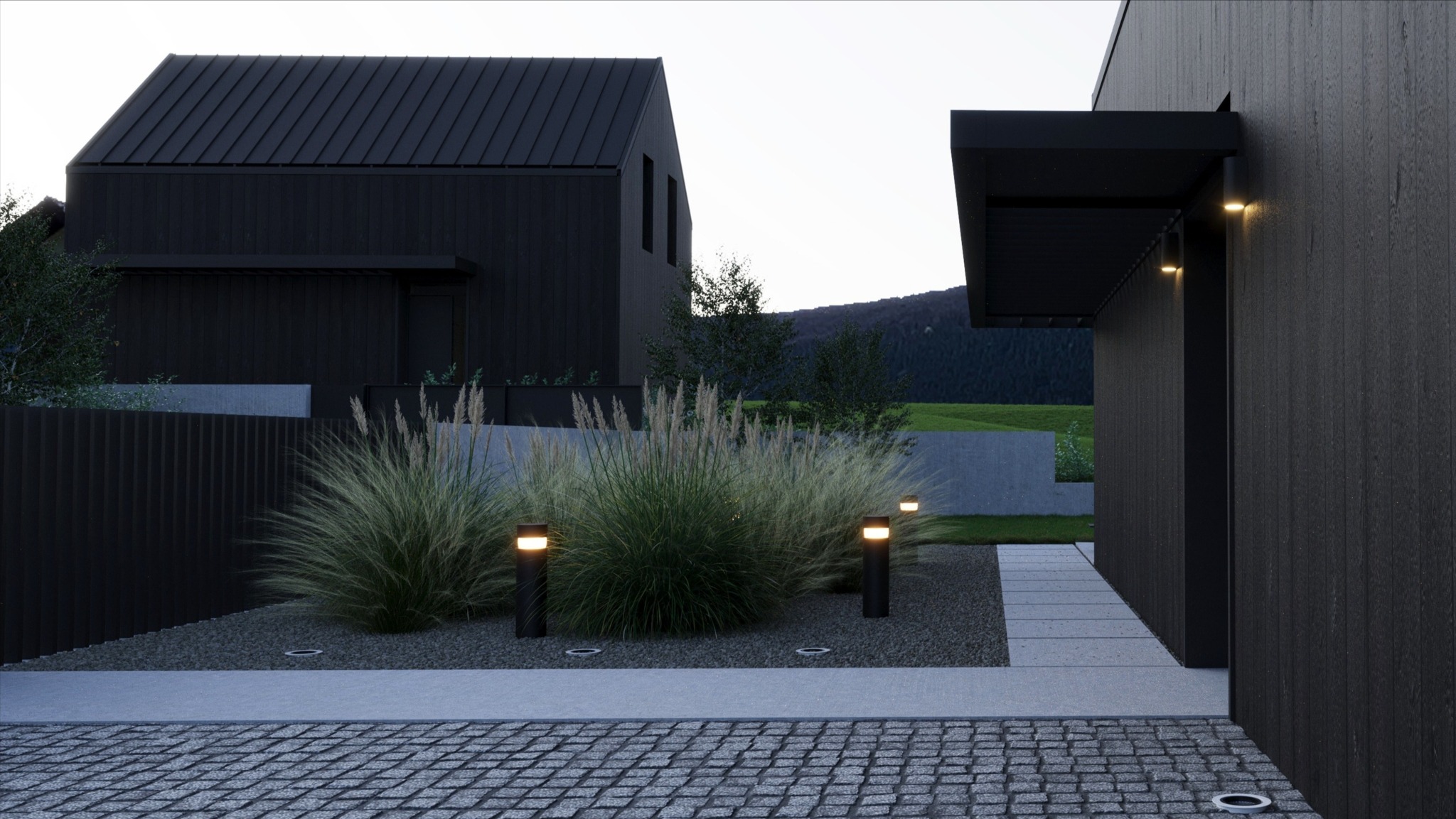 Nowoczesny dom z elewacją z ciemnego drewna, oświetlony lampami ogrodowymi, z dekoracyjną trawą i kamieniami na podwórku, w tle zielone wzgórza.