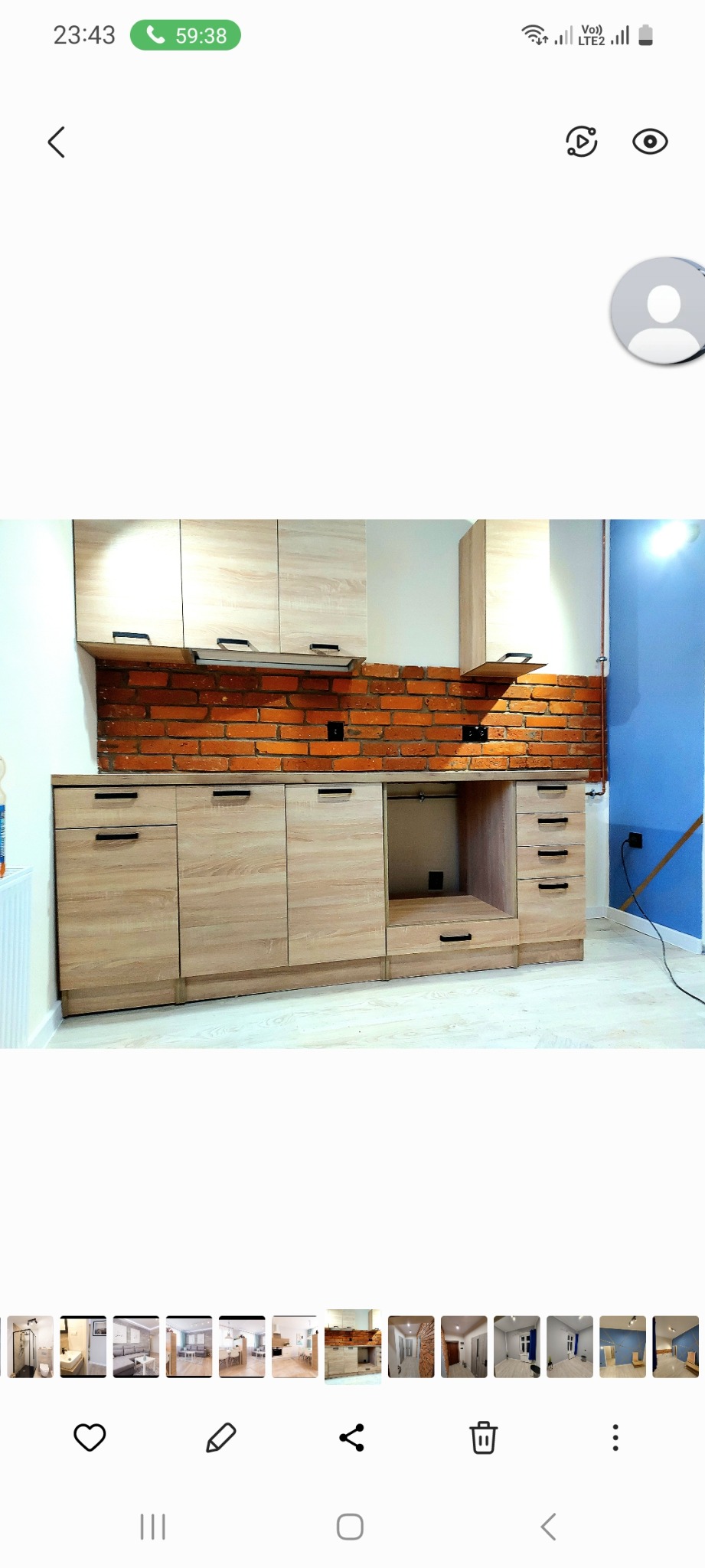 Kuchnia z drewnianymi szafkami, ceglaną ścianą i niebieską ścianą w tle, widok z przodu.